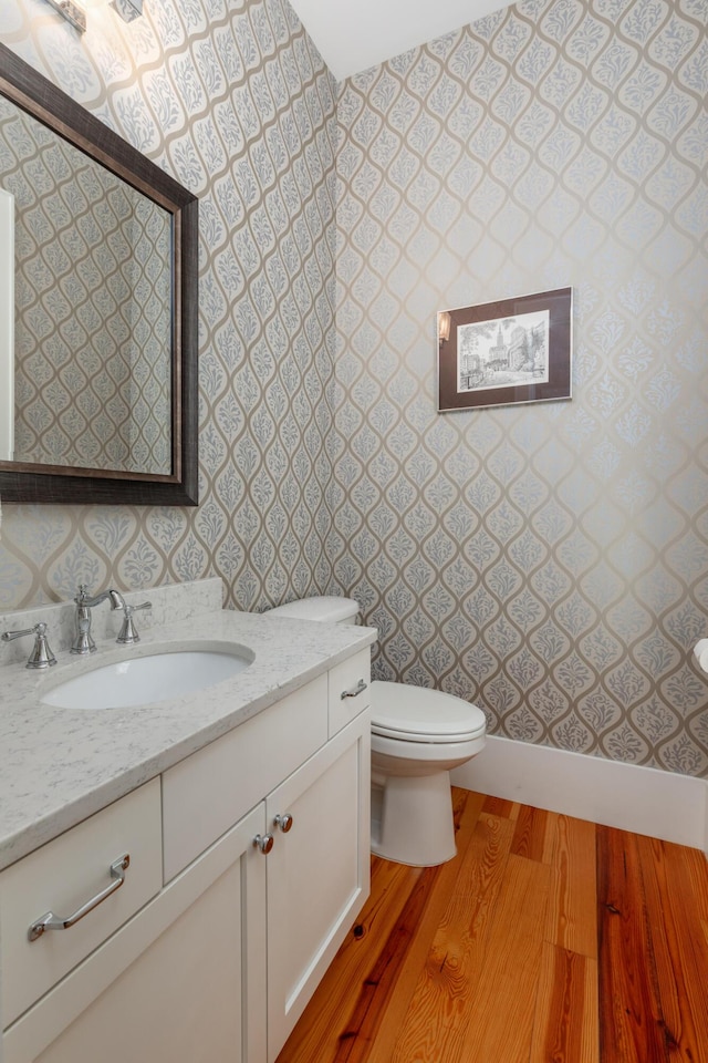 bathroom featuring wood-type flooring, vanity, and toilet