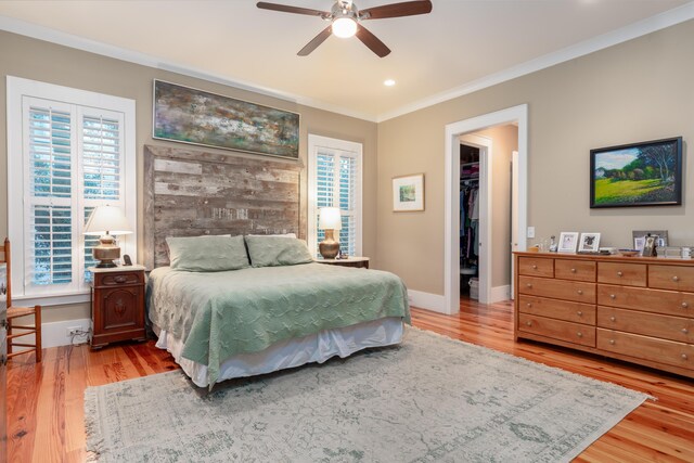 bedroom featuring hardwood / wood-style floors, multiple windows, a spacious closet, ceiling fan, and a closet