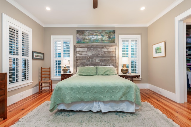 bedroom featuring multiple windows, crown molding, wood-type flooring, and ceiling fan