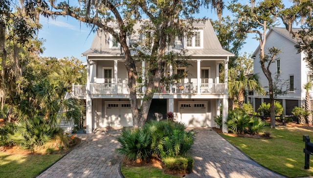 coastal home with a garage and a front lawn