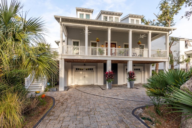 view of front of home with ceiling fan, a garage, and a balcony