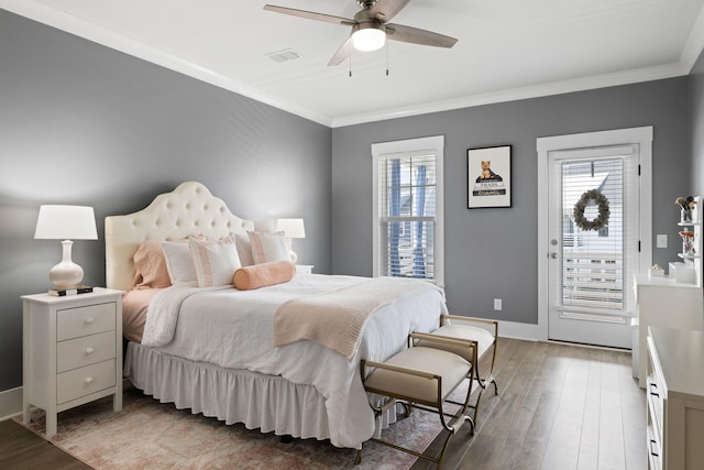 bedroom featuring multiple windows, visible vents, wood finished floors, and ornamental molding