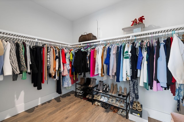 walk in closet with wood finished floors