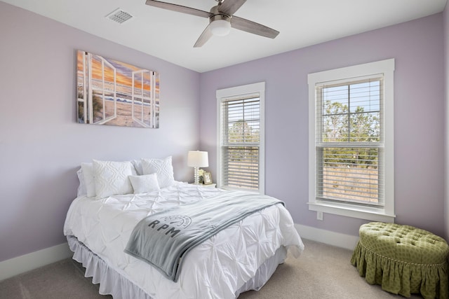 carpeted bedroom with a ceiling fan, visible vents, and baseboards