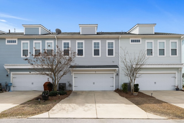 view of property with driveway, an attached garage, and central air condition unit