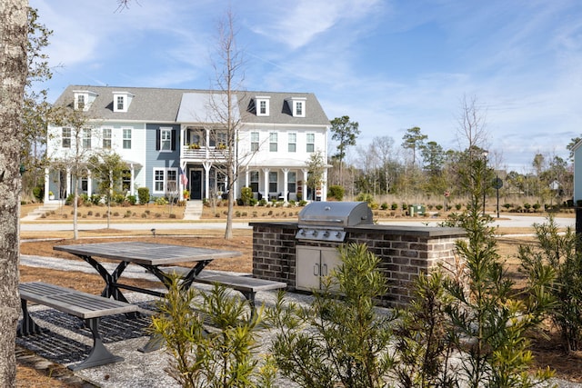 rear view of house featuring a balcony and an outdoor kitchen