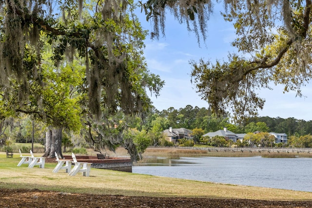 view of home's community featuring a lawn and a water view