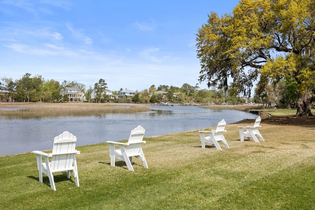 view of dock with a water view and a yard