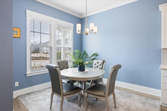 dining space featuring crown molding, baseboards, a chandelier, and wood finished floors