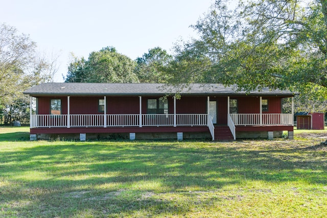 view of front of house featuring a front lawn and a storage shed