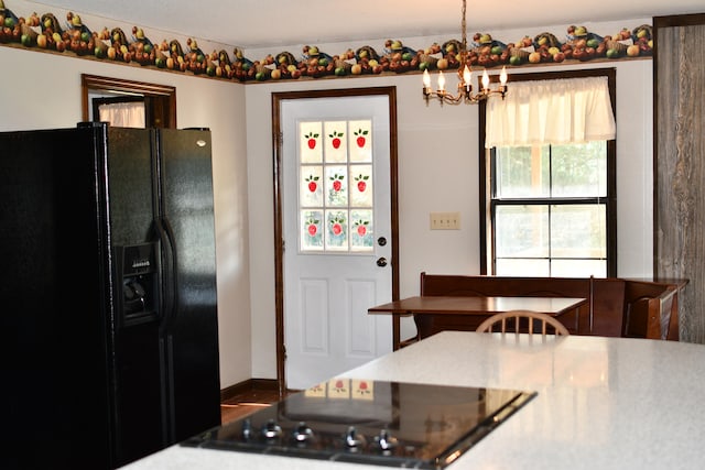 kitchen featuring a chandelier, black appliances, and decorative light fixtures