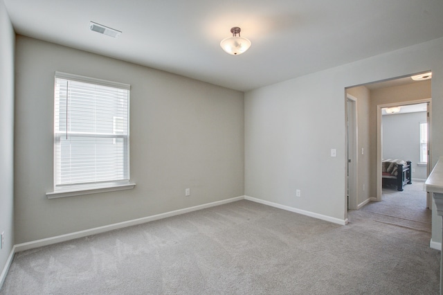 unfurnished room featuring light colored carpet