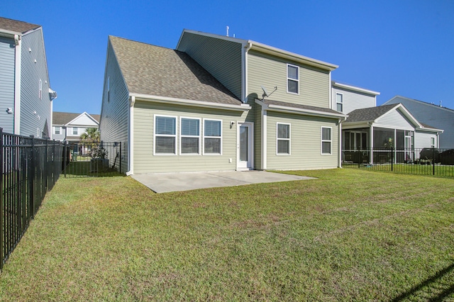 rear view of house featuring a lawn and a patio