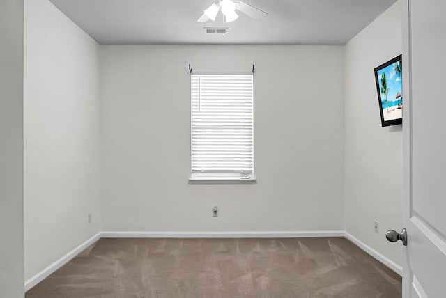 spare room with ceiling fan and light colored carpet