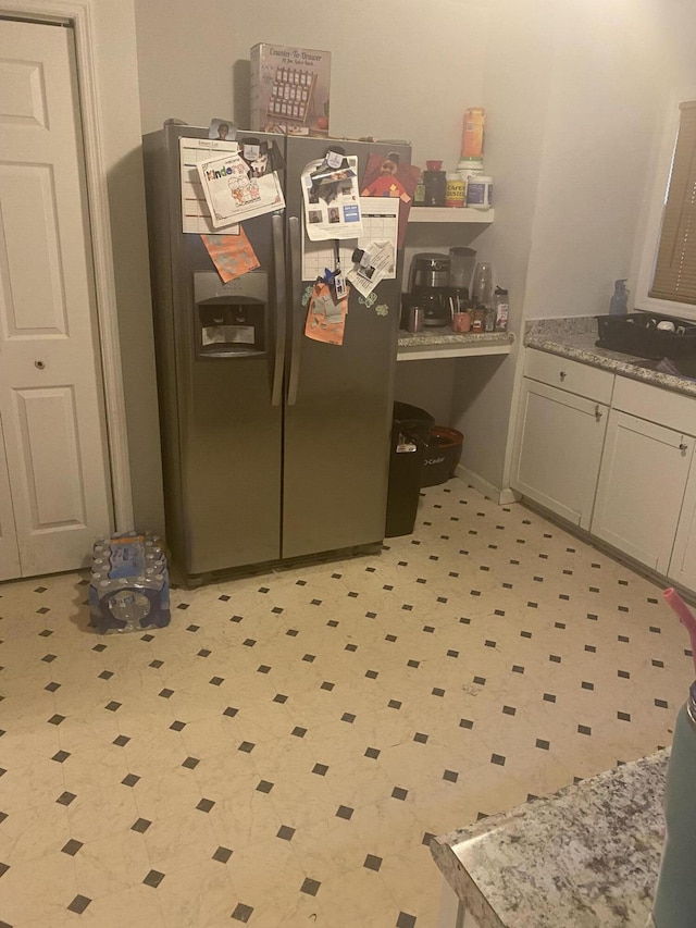 kitchen featuring stainless steel fridge and light floors