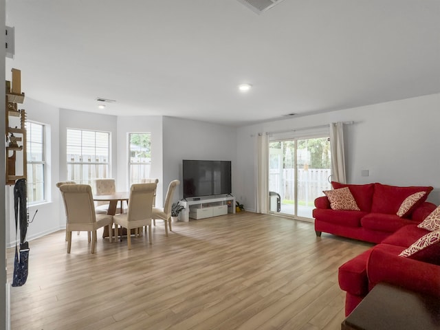 living room featuring a wealth of natural light and light hardwood / wood-style flooring