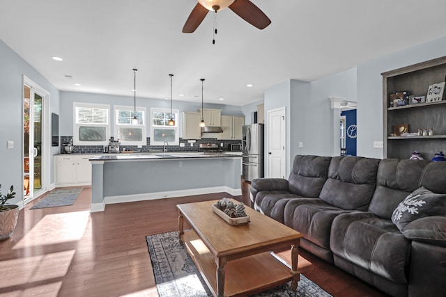 living room with dark hardwood / wood-style floors and ceiling fan