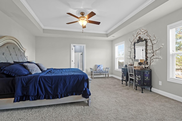 carpeted bedroom with a raised ceiling, ornamental molding, and multiple windows