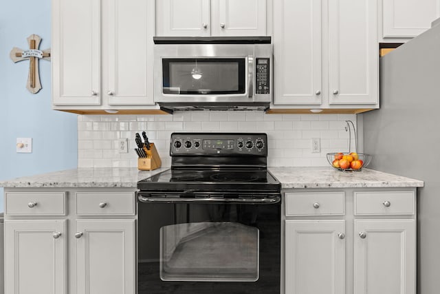 kitchen featuring backsplash, appliances with stainless steel finishes, and white cabinetry