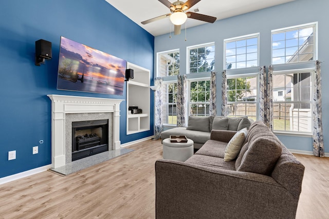 living room with hardwood / wood-style flooring, built in features, and ceiling fan