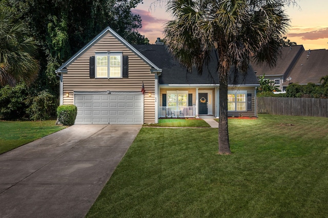 view of front of property with a garage, a yard, and covered porch