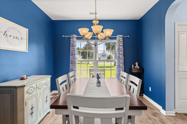 dining space featuring light hardwood / wood-style floors and an inviting chandelier