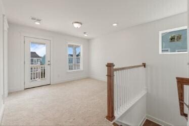 corridor featuring light colored carpet