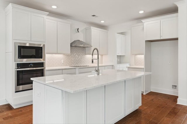 kitchen with dark hardwood / wood-style floors, a center island with sink, white cabinetry, and appliances with stainless steel finishes