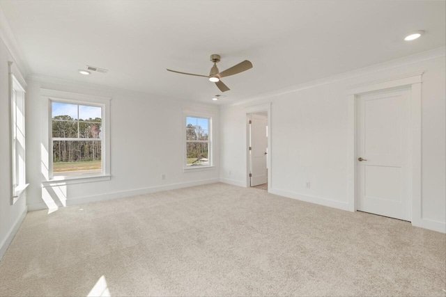 carpeted spare room with ceiling fan and crown molding