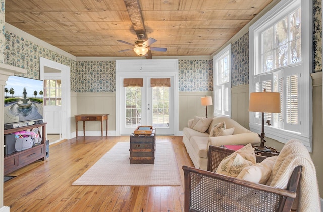 living room with a healthy amount of sunlight, light hardwood / wood-style flooring, wooden ceiling, and french doors