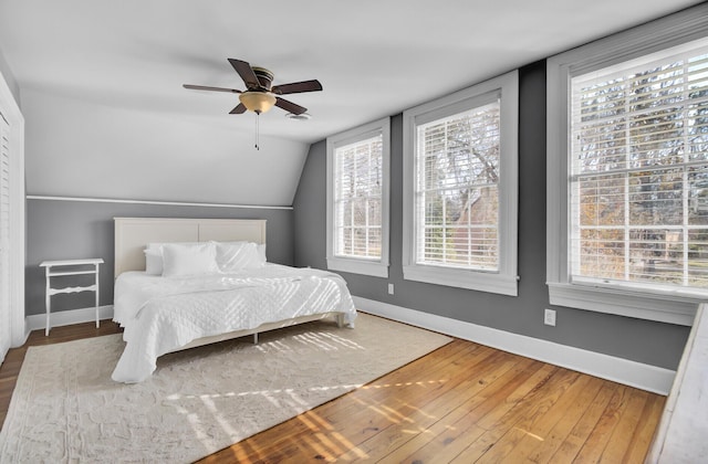 bedroom with hardwood / wood-style flooring, vaulted ceiling, and ceiling fan