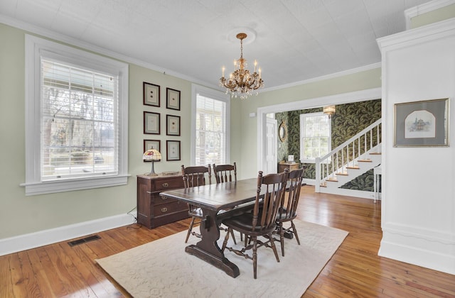 dining room with ornamental molding, light hardwood / wood-style flooring, and plenty of natural light