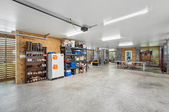 garage featuring white refrigerator and a garage door opener