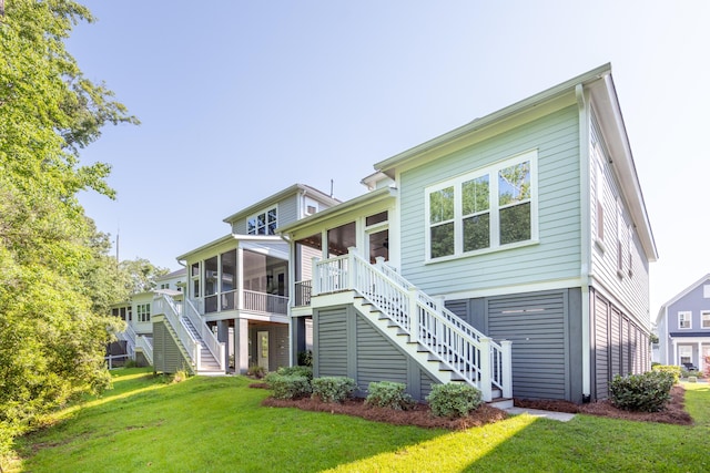 rear view of property with a lawn and a sunroom