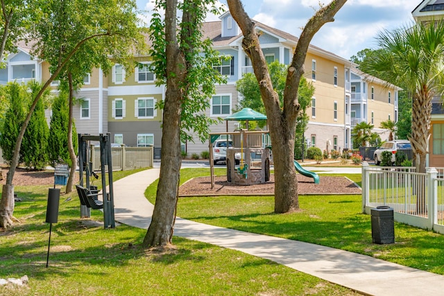 surrounding community featuring a playground and a lawn