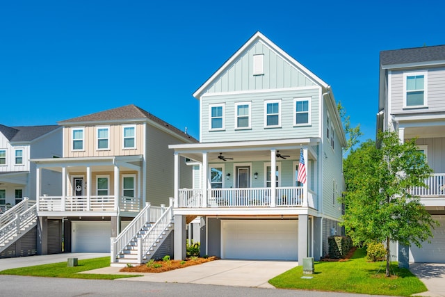 raised beach house with covered porch, a garage, and a front lawn