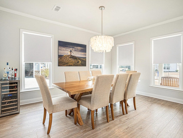 dining area featuring beverage cooler, light wood-type flooring, visible vents, and a healthy amount of sunlight