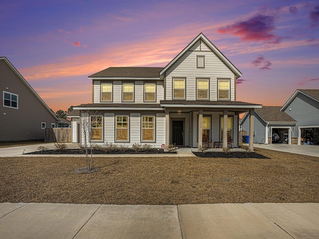 traditional-style house with a porch, driveway, and a garage