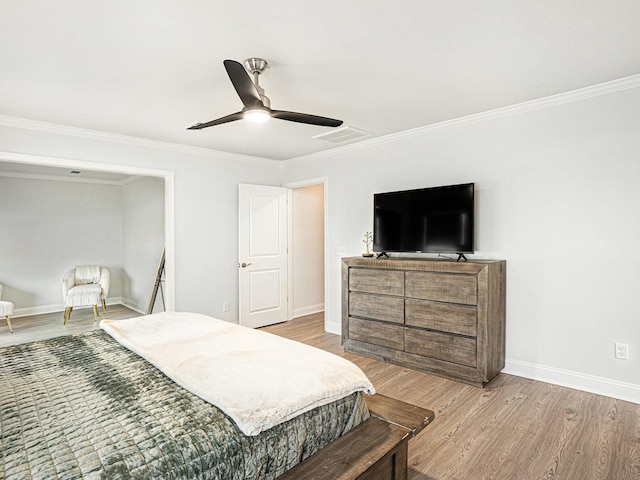 bedroom featuring ornamental molding, visible vents, baseboards, and wood finished floors