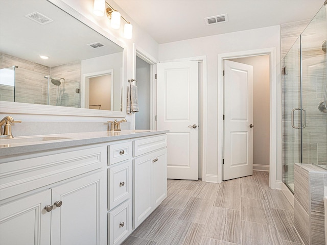 full bathroom featuring a stall shower, visible vents, a sink, and double vanity