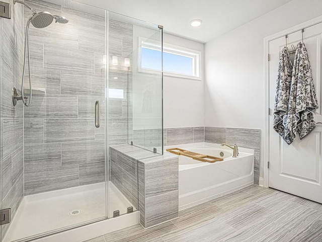 bathroom featuring a garden tub and a shower stall