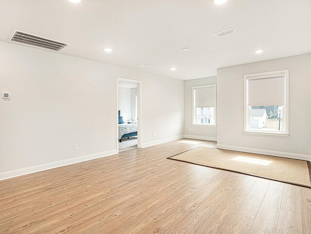 spare room with light wood-type flooring, baseboards, visible vents, and recessed lighting