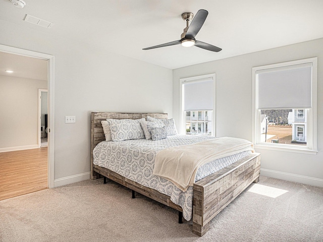 carpeted bedroom featuring multiple windows, visible vents, and baseboards