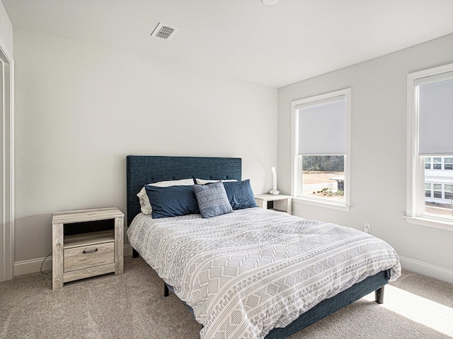 carpeted bedroom featuring baseboards and visible vents