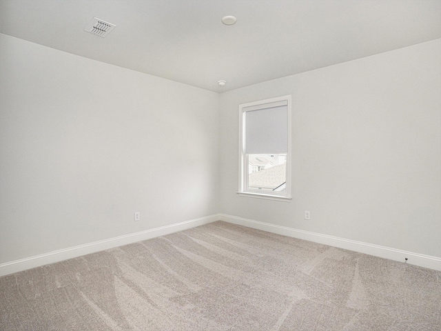 spare room with carpet, visible vents, and baseboards