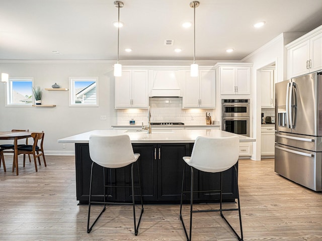 kitchen featuring hanging light fixtures, white cabinetry, stainless steel appliances, and light countertops