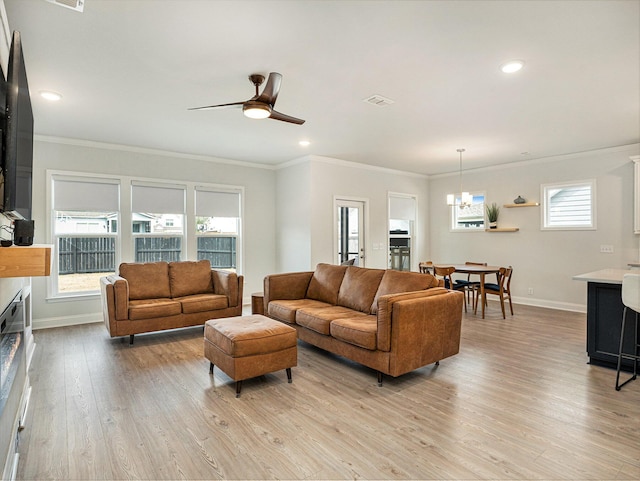 living area with light wood-type flooring, crown molding, baseboards, and a wealth of natural light