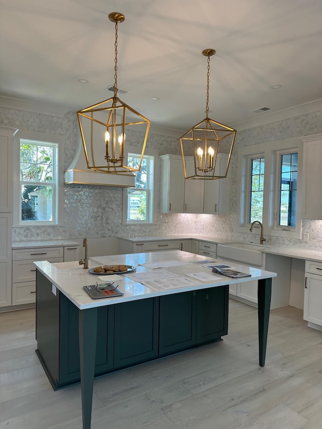 kitchen featuring plenty of natural light, sink, a kitchen island, and pendant lighting