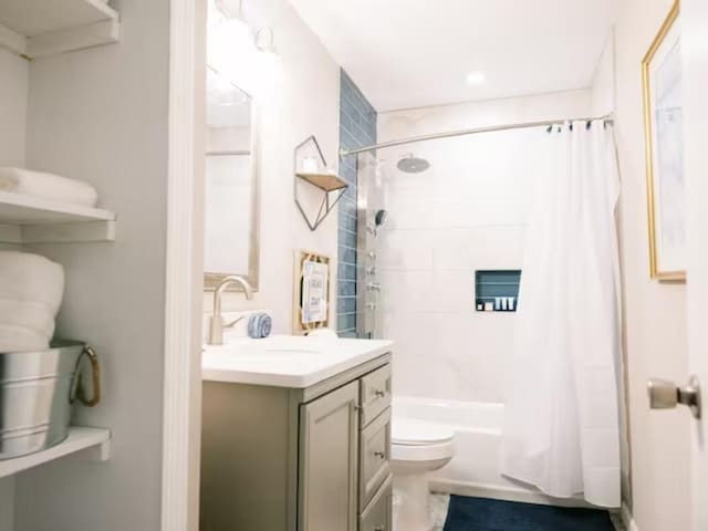 bathroom with toilet, shower / bath combo, and vanity