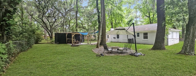 view of yard featuring a fire pit and central AC